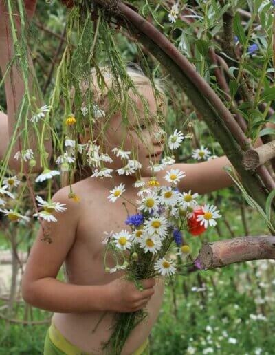 kind met wilde bloemen op plek gemaakt door ontwerper van natuurtuinen