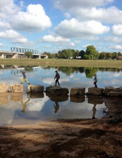 3 kinderen stappen op stenen in Woeste Willem speelnatuur Deventer