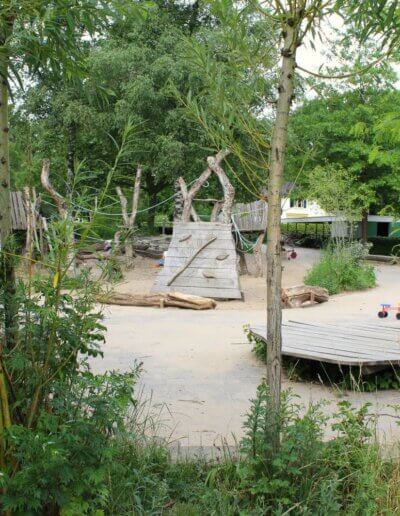 vanuit vogelbosje zicht op natuurlijk schoolplein met natuurlijke speeltoestellen bij Hei en Bos Loenen ontwerp door Nienke Nijhoff