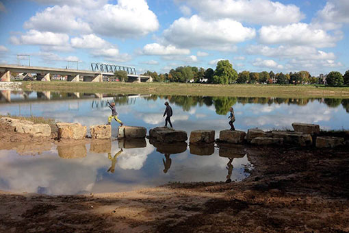 avontuurlijk spelen 3 kinderen stappen op stenen in Woeste Willem speelnatuur